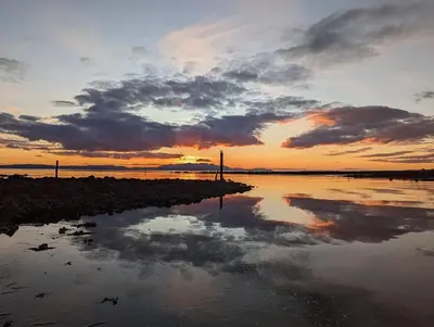 a sunset over a body of water with the sky at Marina View Guest House in Irvine