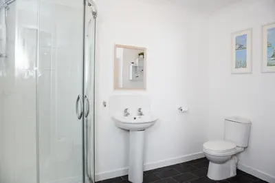 a bathroom with a shower and a toilet and a sink at Marina View Guest House in Irvine