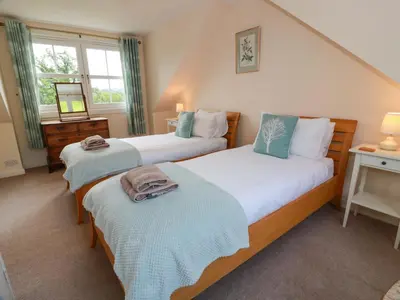 a bedroom with two beds and a window at Cairnhill in Girvan