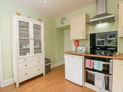 a kitchen with white cabinets and a stove at Cairnhill in Girvan