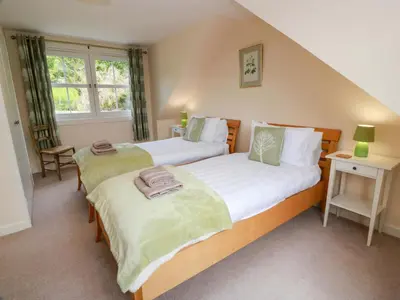 two twin beds in a room with a window at Cairnhill in Girvan