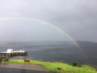 a rainbow over a body of water with a pier at Pier View in Dunoon
