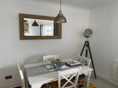 a dining room table with a mirror and a camera at Pier View in Dunoon