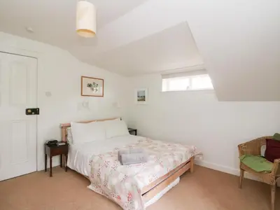 a bedroom with a bed and a chair at Tower Lodge in Dalmally