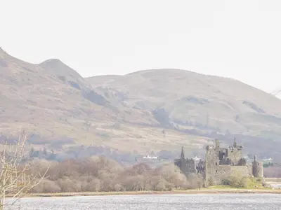 a castle in the middle of a body of water at Tower Lodge in Dalmally