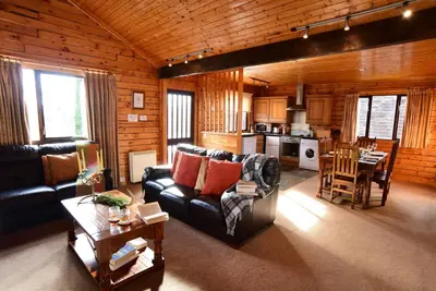 a living room with a couch and a table and a kitchen at Leny Estate in Callander