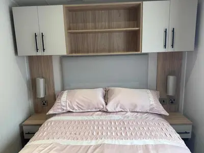 a bedroom with a bed with cabinets above it at The Manor Sea View 1A in Ardentinny