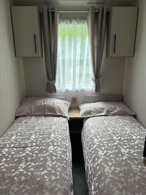 two beds in a small room with a window at The Manor Sea View 1A in Ardentinny