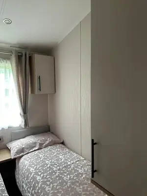a small bedroom with a bed and a cabinet at The Manor Sea View 1A in Ardentinny