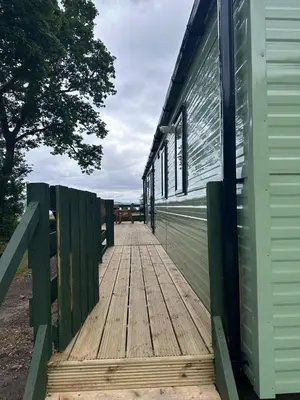 a wooden boardwalk leading up to a building at The Manor Sea View 1A in Ardentinny