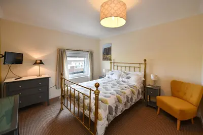 a bedroom with a bed and a chair at Lochans Lodge in Stranraer