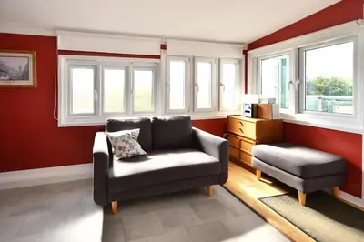a living room with a couch and a chair and windows at Lochans Lodge in Stranraer