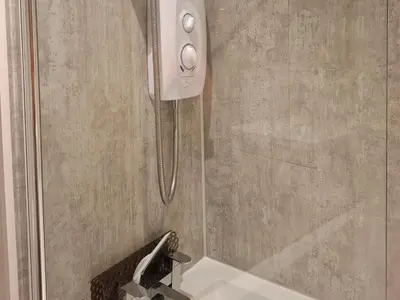 a shower in a bathroom with a faucet at Black Stair Room - En Suite in Helensburgh