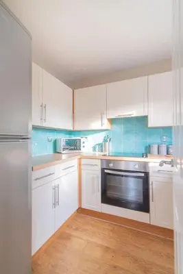 a kitchen with white cabinets and a stainless steel appliance at The Cluthar - Ground Floor West End City Centre Rockvilla flat & Parking in Glasgow