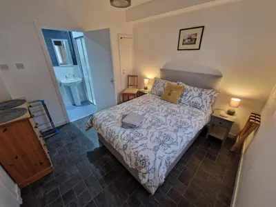a small bedroom with a bed and a sink at Cala Sith Guesthouse in Port Ellen