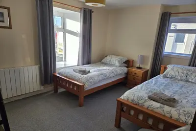 a bedroom with two beds and a window at Cala Sith Guesthouse in Port Ellen