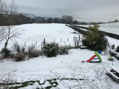 a child playing in the snow in a field at Whiteley’s Cottages studio in Dumbarton