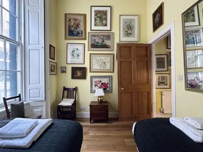 a bedroom with two beds and pictures on the wall at Frederick Street - stylish apartment in the heart of New Town! in Edinburgh