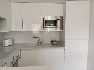 a white kitchen with a sink and a microwave at Executive Annex - Dunfermline in Dunfermline