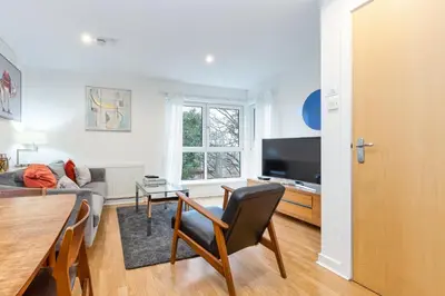 a living room with a couch and a table at Modern 2 bed BroomPark/Central apt. with Parking in Glasgow