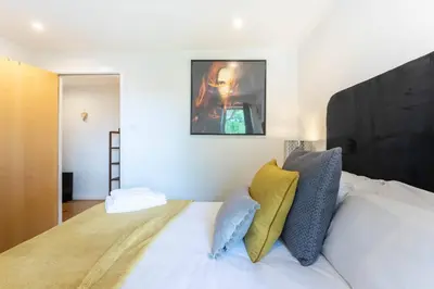 a bedroom with a large bed with yellow and blue pillows at Modern 2 bed BroomPark/Central apt. with Parking in Glasgow