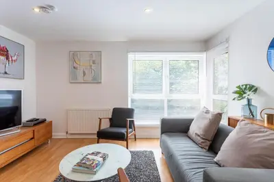 a living room with a couch and a table at Modern 2 bed BroomPark/Central apt. with Parking in Glasgow