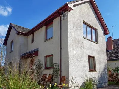 a large white house with windows on it at Lismore Cottage in North Ballachulish
