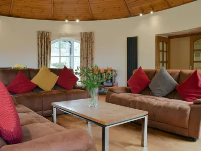 a living room with couches and a vase of flowers on a table at Horsemill - Uk10794 in Ballingry