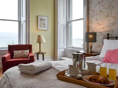 a room with a bed with a tray of food on it at Fircliff - The House On Bute in Port Bannatyne