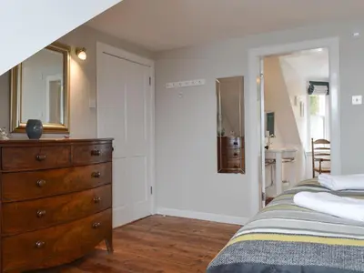 a bedroom with a dresser and a mirror at Fircliff - The House On Bute in Port Bannatyne