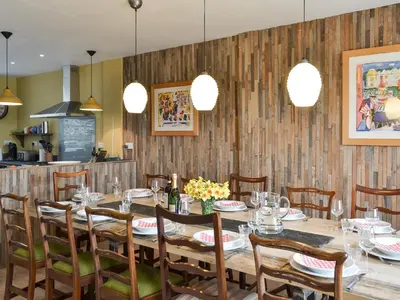 a dining room with a table and chairs and lights at Fircliff - The House On Bute in Port Bannatyne