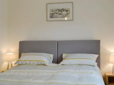 a bed with two pillows and a picture on the wall at Thistlebank in Banknock