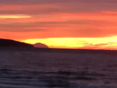 a sunset on the beach with the ocean at No 7 Ayr Beach - Coorie Doon in Ayr