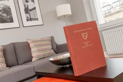 a book sitting on a table next to a couch at Destiny Scotland Hanover Apartments in Edinburgh