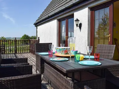 a table with plates and wine glasses on a patio at Lawford Lodge in Bonnybridge