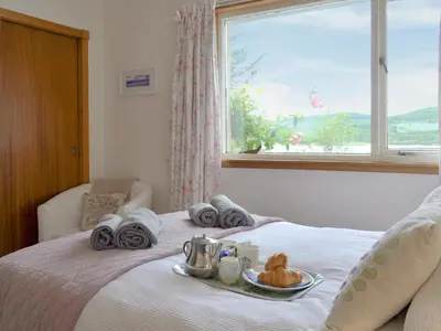 a bed with a tray of food on top of it at Dunyvaig in Colintraive