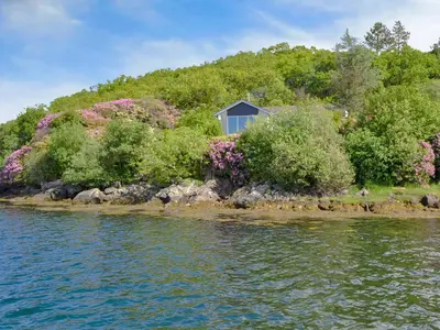 a house on an island in the water at Dunyvaig in Colintraive