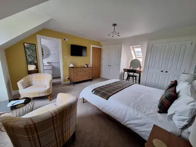 a bedroom with a bed and a living room at Lochview Guesthouse in Corran