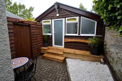 a small cabin with a bench and a window at Craiglockhart Lodge in Edinburgh