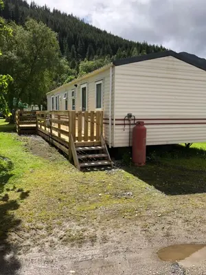 a mobile home with a wooden fence and a fire hydrant at Bermuda 29 in Dunoon