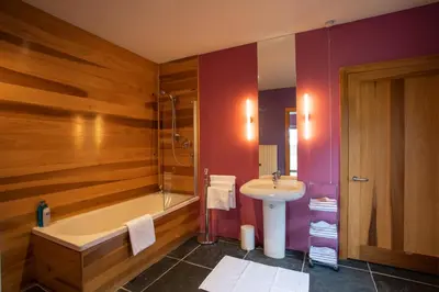 a bathroom with a tub and a sink at Powdermills B & B in Inveraray