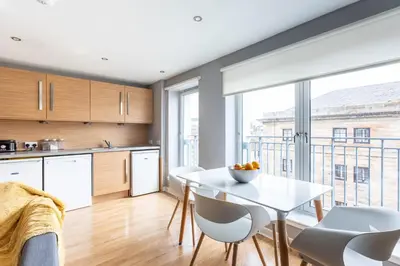 a kitchen and dining room with a table and chairs at Merchant City Modern 1 Bed Executive Flat in Glasgow