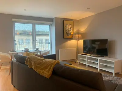 a living room with a couch and a television at Merchant City Modern 1 Bed Executive Flat in Glasgow
