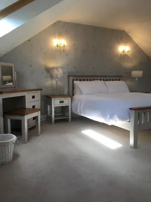 a bedroom with a bed and two night stands and a tv at South Doll Farm Cottage in Airth