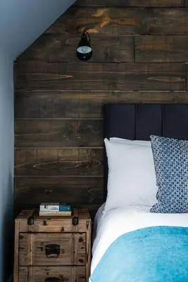 a bedroom with a wooden headboard and a white bed at The Kilchrenan Inn in Oban