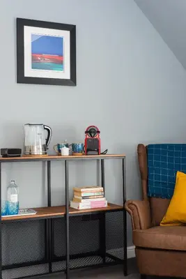 a table next to a chair and a table with books at The Kilchrenan Inn in Oban