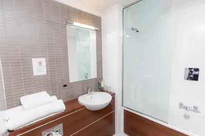 a bathroom with a sink and a shower at Fletcher's Restaurant Bar & Rooms in Stirling