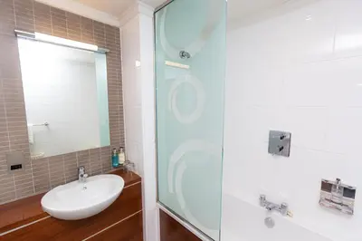 a bathroom with a sink and a glass shower at Fletcher's Restaurant Bar & Rooms in Stirling