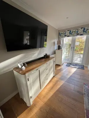 a living room with a large flat screen tv on the wall at Kilmory Garden by the Loch in Lochgilphead