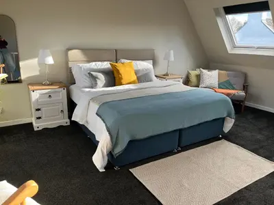 a bedroom with a large bed and a window at Kilmory Garden by the Loch in Lochgilphead